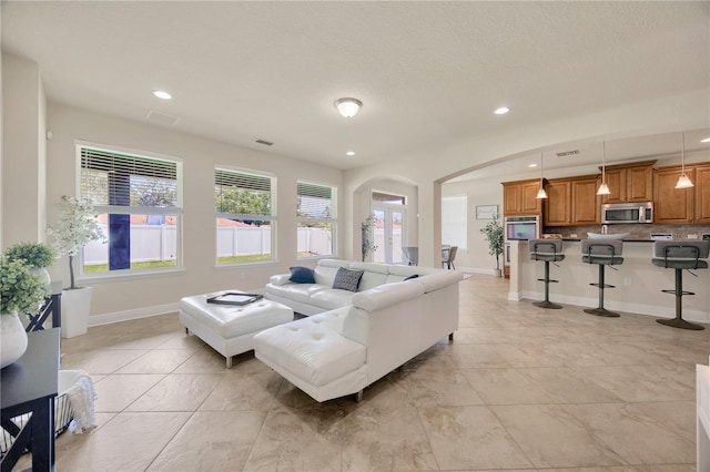 1229 Hillandale Reserve Dr, Tampa, FL 33613 - living room with arched walkways, recessed lighting, and light tile patterned flooring