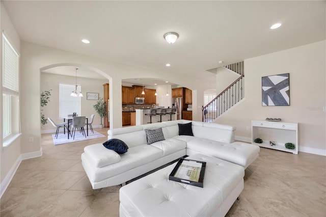 1229 Hillandale Reserve Dr, Tampa, FL 33613 - living room with arched walkways, plenty of natural light, recessed lighting, stairs, and light tile patterned floors