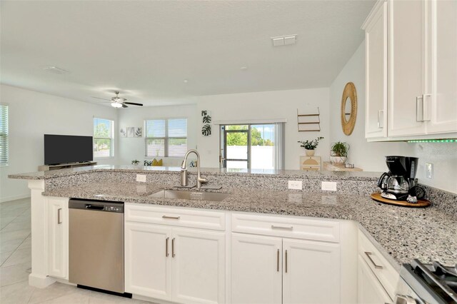 3228 Bryant Park Dr, New Port Richey, FL 34655 - kitchen with stainless steel appliances, a sink, light tile patterned floors, light stone countertops, and white cabinets