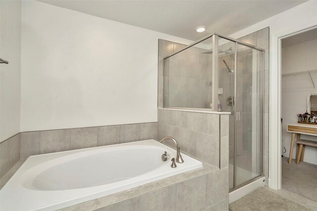 3228 Bryant Park Dr, New Port Richey, FL 34655 - bathroom featuring a garden tub, a stall shower, and a walk in closet