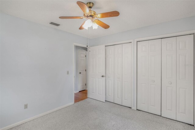 3341 S Jean Pt, Inverness, FL 34450 - unfurnished bedroom with carpet flooring, multiple closets, baseboards, and a ceiling fan