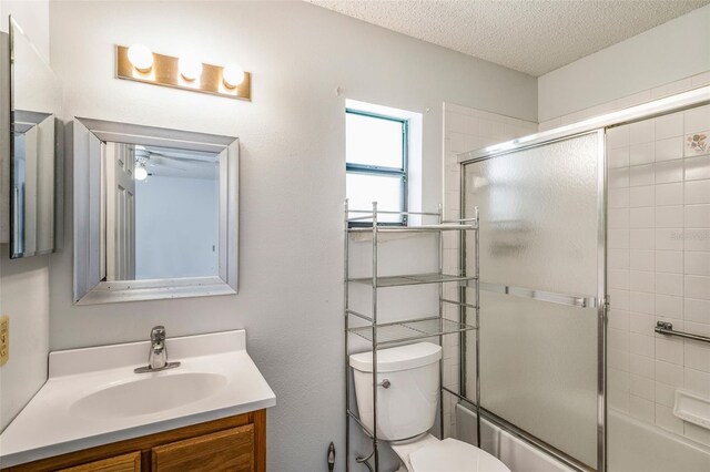 3341 S Jean Pt, Inverness, FL 34450 - bathroom featuring vanity, toilet, bath / shower combo with glass door, and a textured ceiling