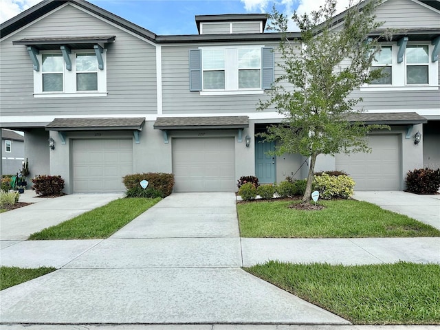 2717 Chestnut Creek Pl, Brandon, FL 33510 - townhome / multi-family property with an attached garage, stucco siding, roof with shingles, concrete driveway, and a front lawn
