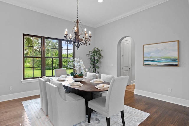 7713 Still Lakes Dr, Odessa, FL 33556 - dining room with arched walkways, baseboards, a chandelier, wood finished floors, and crown molding