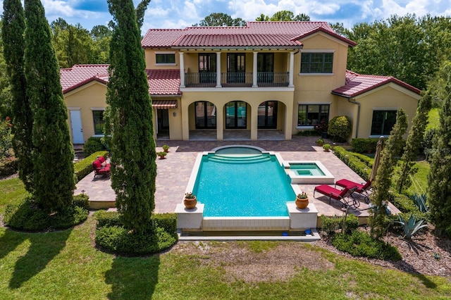 7713 Still Lakes Dr, Odessa, FL 33556 - rear view of house with a balcony, a patio area, a tile roof, stucco siding, and a pool with connected hot tub
