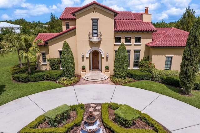 7713 Still Lakes Dr, Odessa, FL 33556 - mediterranean / spanish-style house featuring a balcony, a chimney, stucco siding, and a tiled roof
