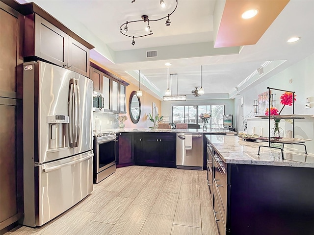 3334 Purple Martin Dr Unit 212, Punta Gorda, FL 33950 - kitchen featuring appliances with stainless steel finishes, a peninsula, light stone countertops, recessed lighting, and pendant lighting