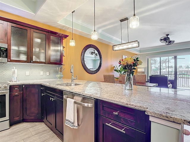3334 Purple Martin Dr Unit 212, Punta Gorda, FL 33950 - kitchen with stainless steel appliances, a peninsula, light stone counters, backsplash, and a sink