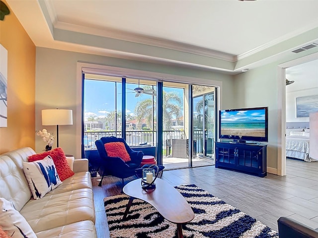 3334 Purple Martin Dr Unit 212, Punta Gorda, FL 33950 - living room with ornamental molding, a tray ceiling, baseboards, and wood finish floors