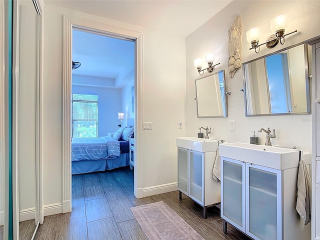 3334 Purple Martin Dr Unit 212, Punta Gorda, FL 33950 - full bathroom featuring ensuite bathroom, baseboards, two vanities, and wood finished floors