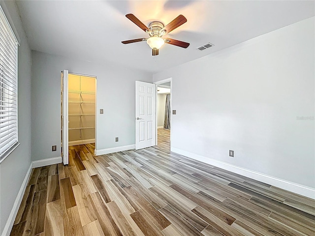 66 Bay Woods Dr, Safety Harbor, FL 34695 - unfurnished bedroom featuring wood finished floors, a spacious closet, baseboards, and a closet