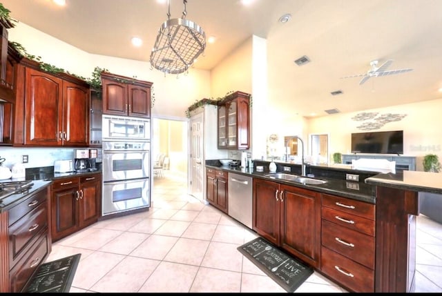 514 Harbor Dr N, Indian Rocks Beach, FL 33785 - kitchen with stainless steel appliances, a sink, light tile patterned floors, a peninsula, and dark brown cabinets