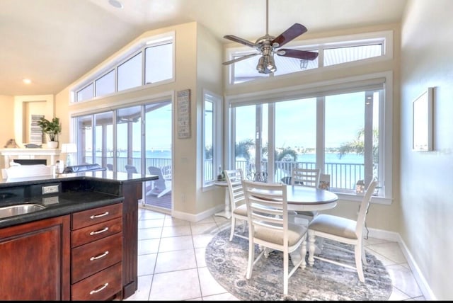 514 Harbor Dr N, Indian Rocks Beach, FL 33785 - kitchen featuring a ceiling fan, dark countertops, light tile patterned floors, baseboards, and high vaulted ceiling