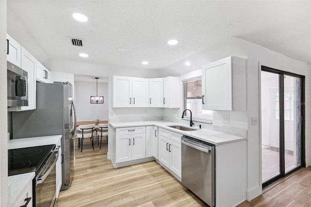 622 Cedar Grove Dr, Brandon, FL 33511 - kitchen featuring stainless steel appliances, a sink, light wood-style flooring, white cabinets, and recessed lighting