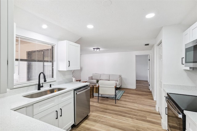 622 Cedar Grove Dr, Brandon, FL 33511 - kitchen with a sink, stainless steel appliances, white cabinets, recessed lighting, and light wood-style floors