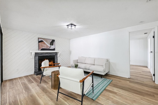 622 Cedar Grove Dr, Brandon, FL 33511 - living area featuring light wood-style floors, a fireplace, baseboards, and a textured ceiling