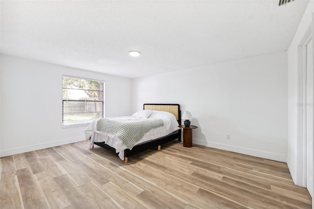 622 Cedar Grove Dr, Brandon, FL 33511 - bedroom with light wood finished floors, baseboards, and a textured ceiling