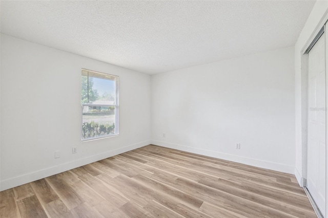 622 Cedar Grove Dr, Brandon, FL 33511 - unfurnished bedroom featuring light wood-style floors, a textured ceiling, baseboards, and a closet