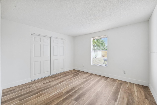622 Cedar Grove Dr, Brandon, FL 33511 - unfurnished bedroom featuring light wood-style flooring, a textured ceiling, a closet, and baseboards