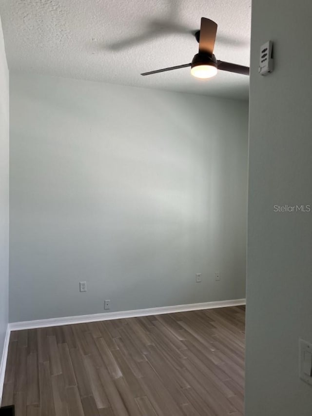 14510 Mj Rd, Myakka City, FL 34251 - unfurnished room featuring dark wood-style floors, a ceiling fan, a textured ceiling, and baseboards