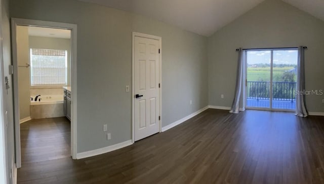 14510 Mj Rd, Myakka City, FL 34251 - unfurnished bedroom with access to outside, multiple windows, dark wood-style flooring, connected bathroom, and lofted ceiling