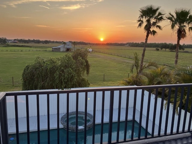 14510 Mj Rd, Myakka City, FL 34251 - balcony at dusk featuring a view of countryside, view of pool area, and a pool with connected hot tub