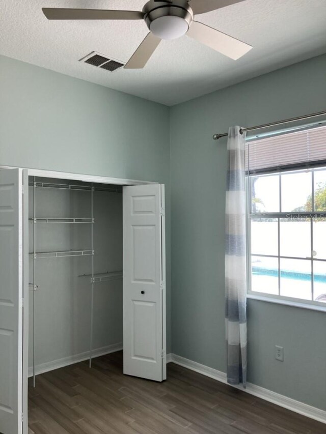 14510 Mj Rd, Myakka City, FL 34251 - unfurnished bedroom featuring dark wood-type flooring, a closet, baseboards, and a ceiling fan