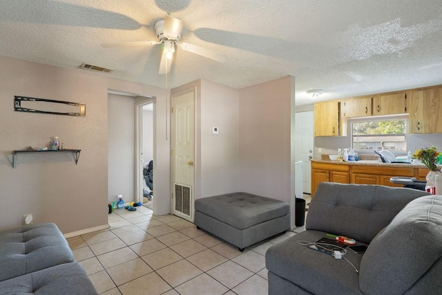 1224 S Delaware Ave, Deland, FL 32720 - living room featuring a textured ceiling, a ceiling fan, light tile patterned floors, and baseboards