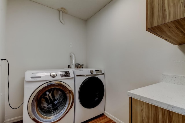 5435 Birchwood Rd, Spring Hill, FL 34608 - laundry room featuring independent washer and dryer, baseboards, light wood finished floors, and cabinet space