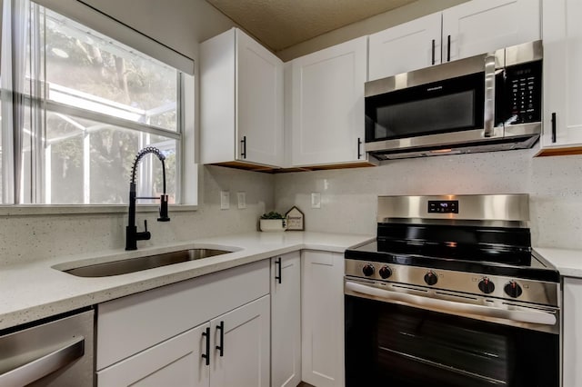 5435 Birchwood Rd, Spring Hill, FL 34608 - kitchen featuring stainless steel appliances, a sink, white cabinets, and light stone counters