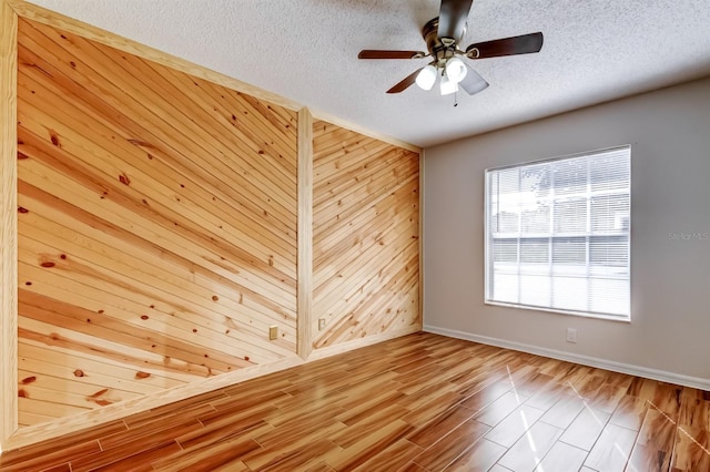 5435 Birchwood Rd, Spring Hill, FL 34608 - unfurnished room featuring baseboards, wood finished floors, a textured ceiling, a ceiling fan, and wood walls