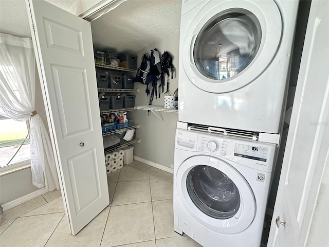 489 Fox Run Trl, Apollo Beach, FL 33572 - laundry area with stacked washing machine and dryer, light tile patterned flooring, baseboards, and a textured ceiling