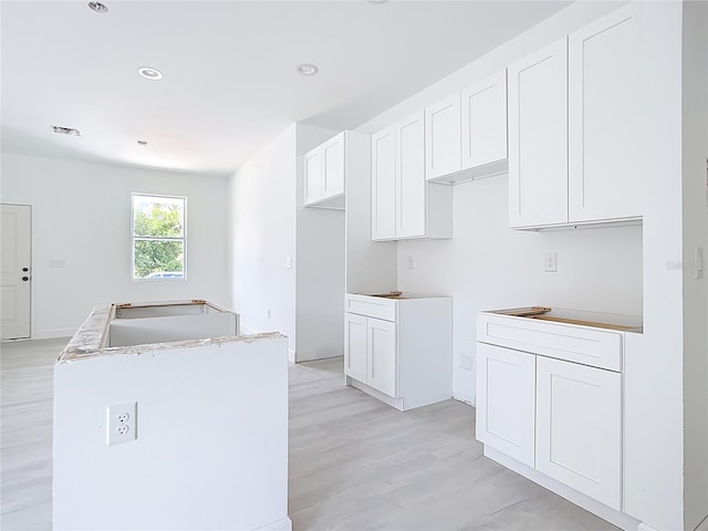 16134 Libourn Ave, Port Charlotte, FL 33954 - kitchen featuring a sink, a kitchen island, light wood-style flooring, white cabinetry, and recessed lighting