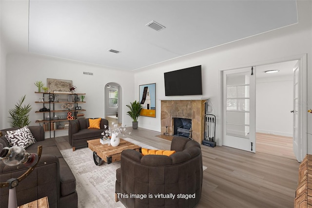 2449 16th St N, Saint Petersburg, FL 33704 - living area with arched walkways, wood finished floors, and a tiled fireplace