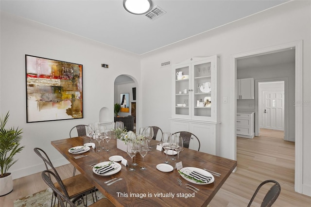2449 16th St N, Saint Petersburg, FL 33704 - dining room with arched walkways, light wood-type flooring, and baseboards