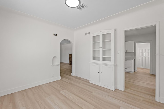 2449 16th St N, Saint Petersburg, FL 33704 - spare room featuring arched walkways, light wood-style floors, and baseboards