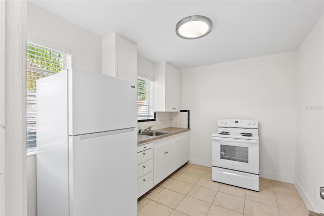 2449 16th St N, Saint Petersburg, FL 33704 - kitchen with white appliances, white cabinetry, light tile patterned floors, tasteful backsplash, and light countertops