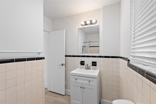 2449 16th St N, Saint Petersburg, FL 33704 - bathroom featuring tile walls, vanity, a wainscoted wall, toilet, and a shower with shower curtain