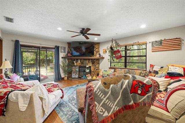 717 E 137th Ave, Tampa, FL 33613 - living area with wood finished floors, ceiling fan, a textured ceiling, recessed lighting, and a stone fireplace