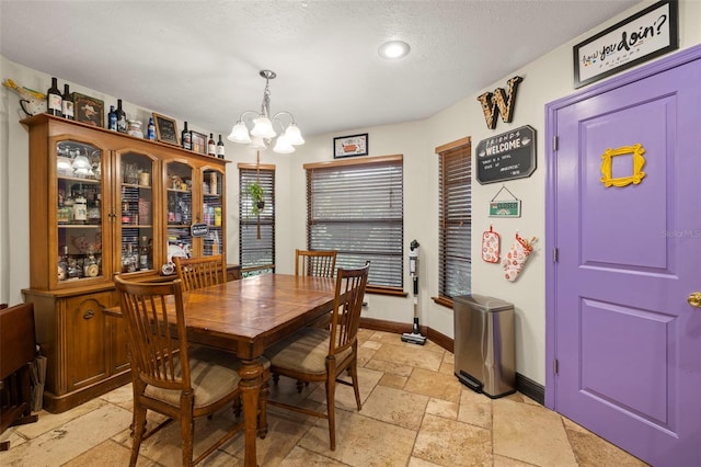 717 E 137th Ave, Tampa, FL 33613 - dining space featuring stone tile floors, a chandelier, baseboards, recessed lighting, and a textured ceiling