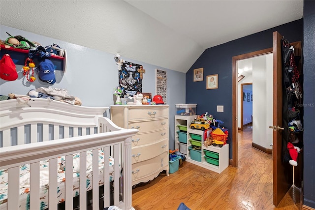 717 E 137th Ave, Tampa, FL 33613 - bedroom with light wood-style floors, vaulted ceiling, and a nursery area