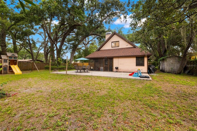 717 E 137th Ave, Tampa, FL 33613 - back of property featuring a playground, a patio area, and a chimney