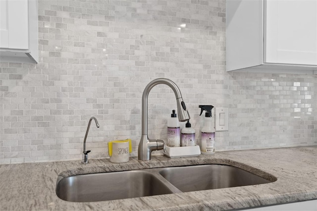 7304 Lakeside Blvd, Tampa, FL 33614 - kitchen view of a sink, backsplash, white cabinets, and light stone countertops
