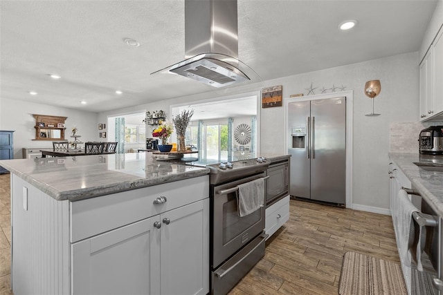 7304 Lakeside Blvd, Tampa, FL 33614 - kitchen with appliances with stainless steel finishes, island exhaust hood, white cabinetry, wood finished floors, and recessed lighting