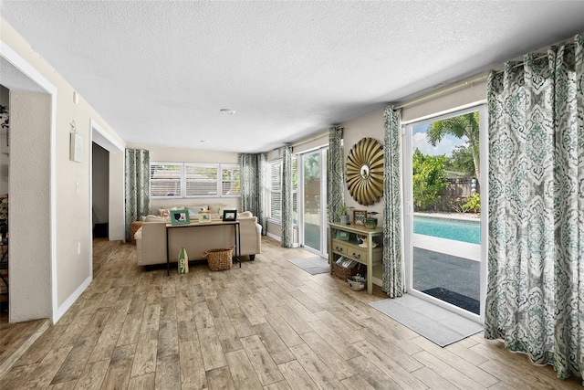 7304 Lakeside Blvd, Tampa, FL 33614 - sunroom / solarium featuring wood finished floors, a textured ceiling, and baseboards