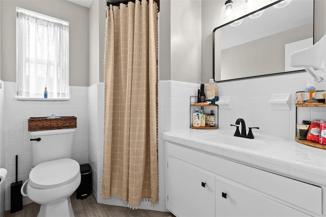 7304 Lakeside Blvd, Tampa, FL 33614 - bathroom featuring tile walls, vanity, toilet, wainscoting, and a shower with shower curtain