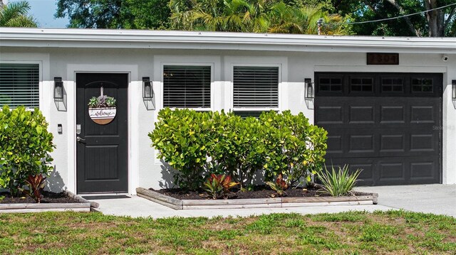 7304 Lakeside Blvd, Tampa, FL 33614 - property entrance with a garage and stucco siding
