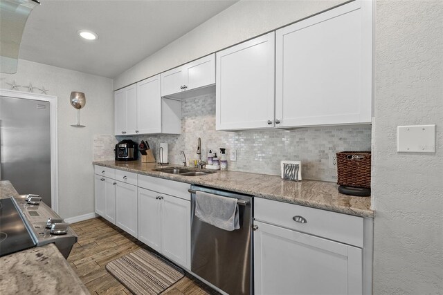7304 Lakeside Blvd, Tampa, FL 33614 - kitchen featuring dishwasher, a sink, decorative backsplash, white cabinetry, and a textured wall