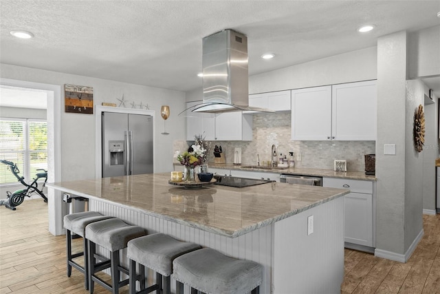 7304 Lakeside Blvd, Tampa, FL 33614 - kitchen with appliances with stainless steel finishes, island range hood, a sink, light wood finished floors, and a kitchen island