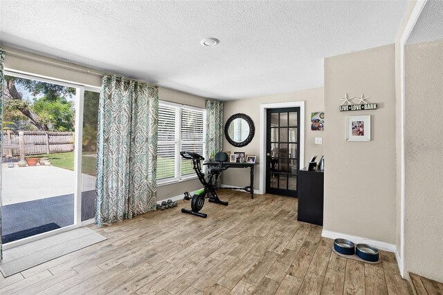 7304 Lakeside Blvd, Tampa, FL 33614 - workout area with a textured ceiling, light wood-type flooring, and baseboards
